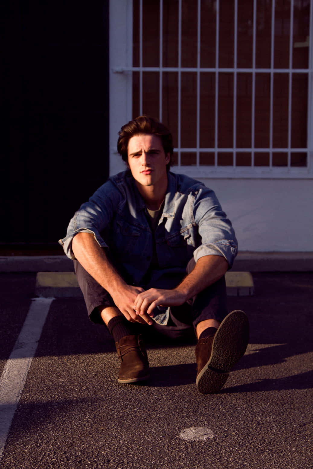 Jacob Elordi Stares Into The Camera While Sitting In A Director's Chair. Background