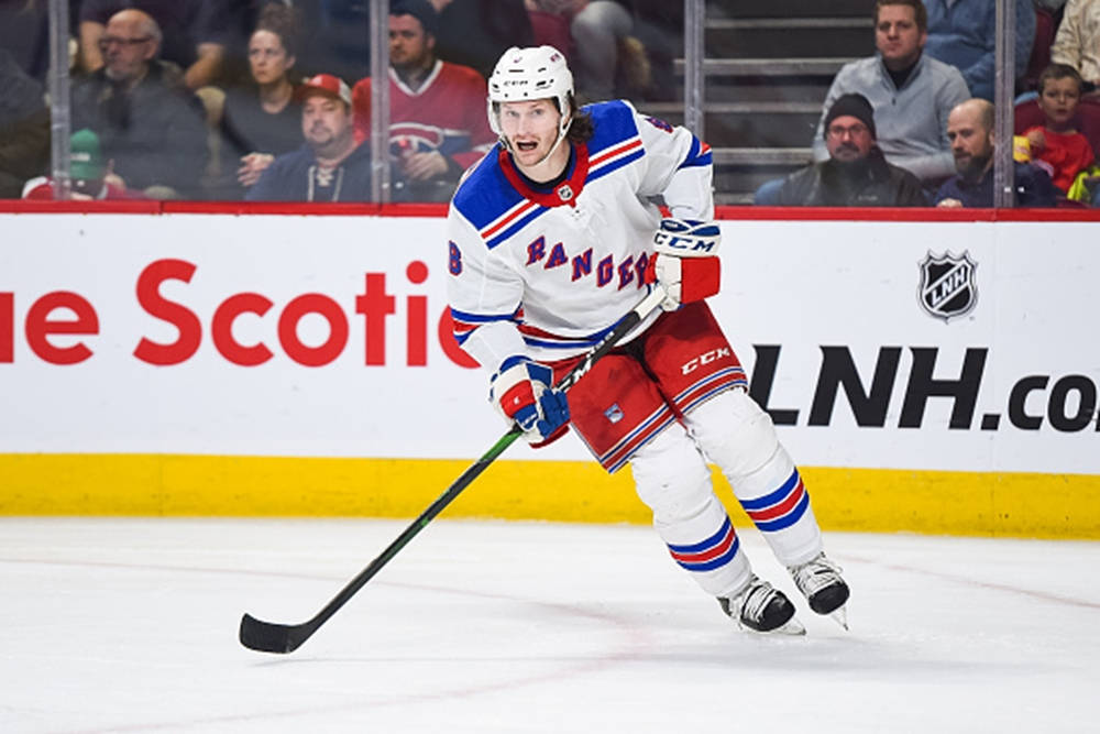 Jacob Trouba From New York Rangers Leaning To The Right While Holding Hockey Stick Background