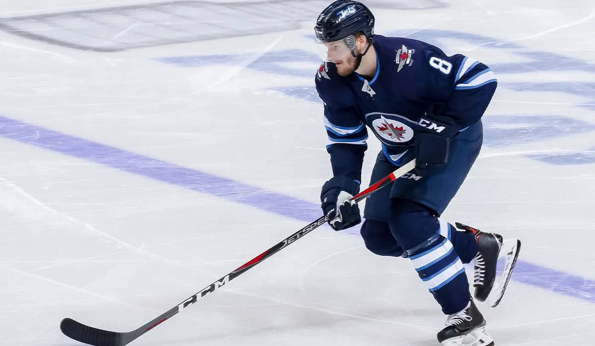 Jacob Trouba Gliding On Ice While Holding Hockey Stick In Front During Game Background