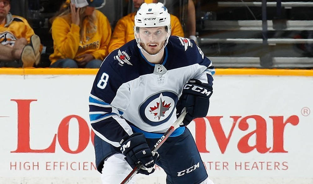 Jacob Trouba Leaning Forward While Holding Hockey Stick Background