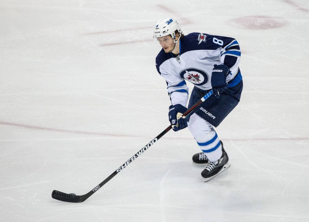 Jacob Trouba Leaning To The Left While Holding Hockey Stick Background