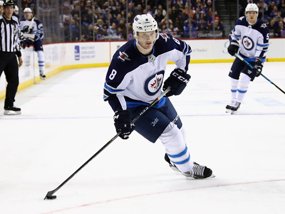 Jacob Trouba Leaning To The Right While Holding Hockey Stick Background