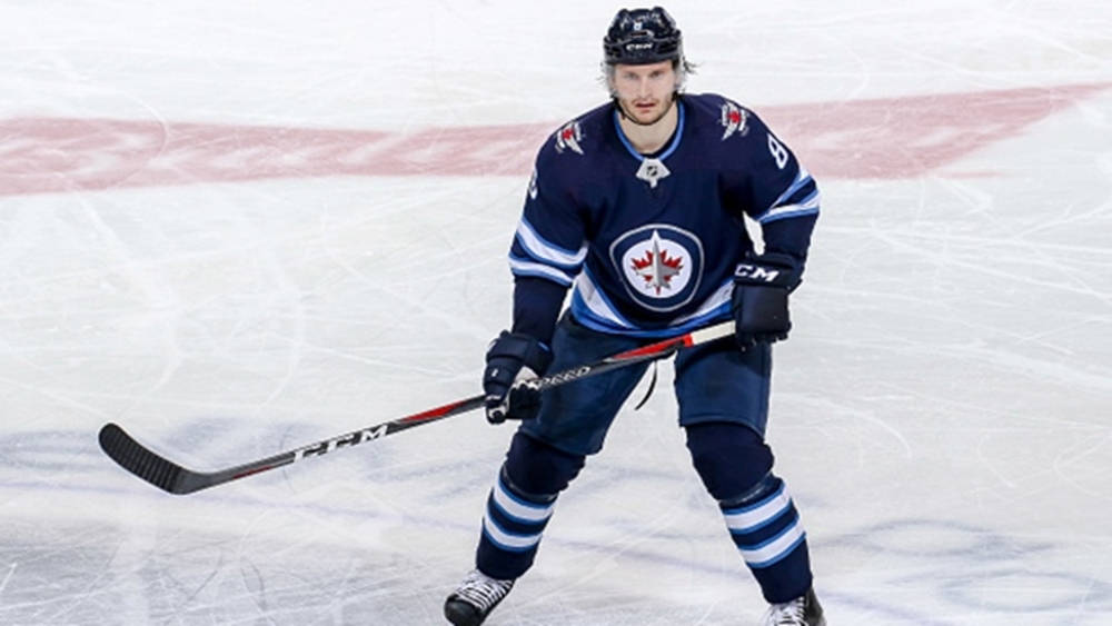 Jacob Trouba Raising His Hockey Stick During A Game Background