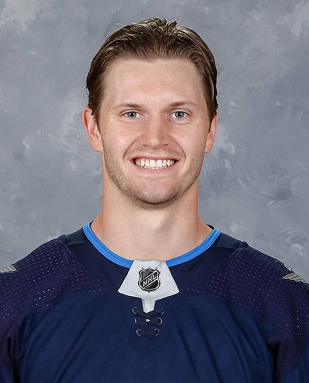 Jacob Trouba Smiling For The Camera Wearing Blue Jersey Background