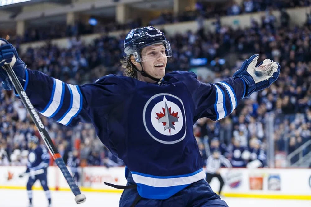 Jacob Trouba Smiling With Hands Open Wide During Game Background