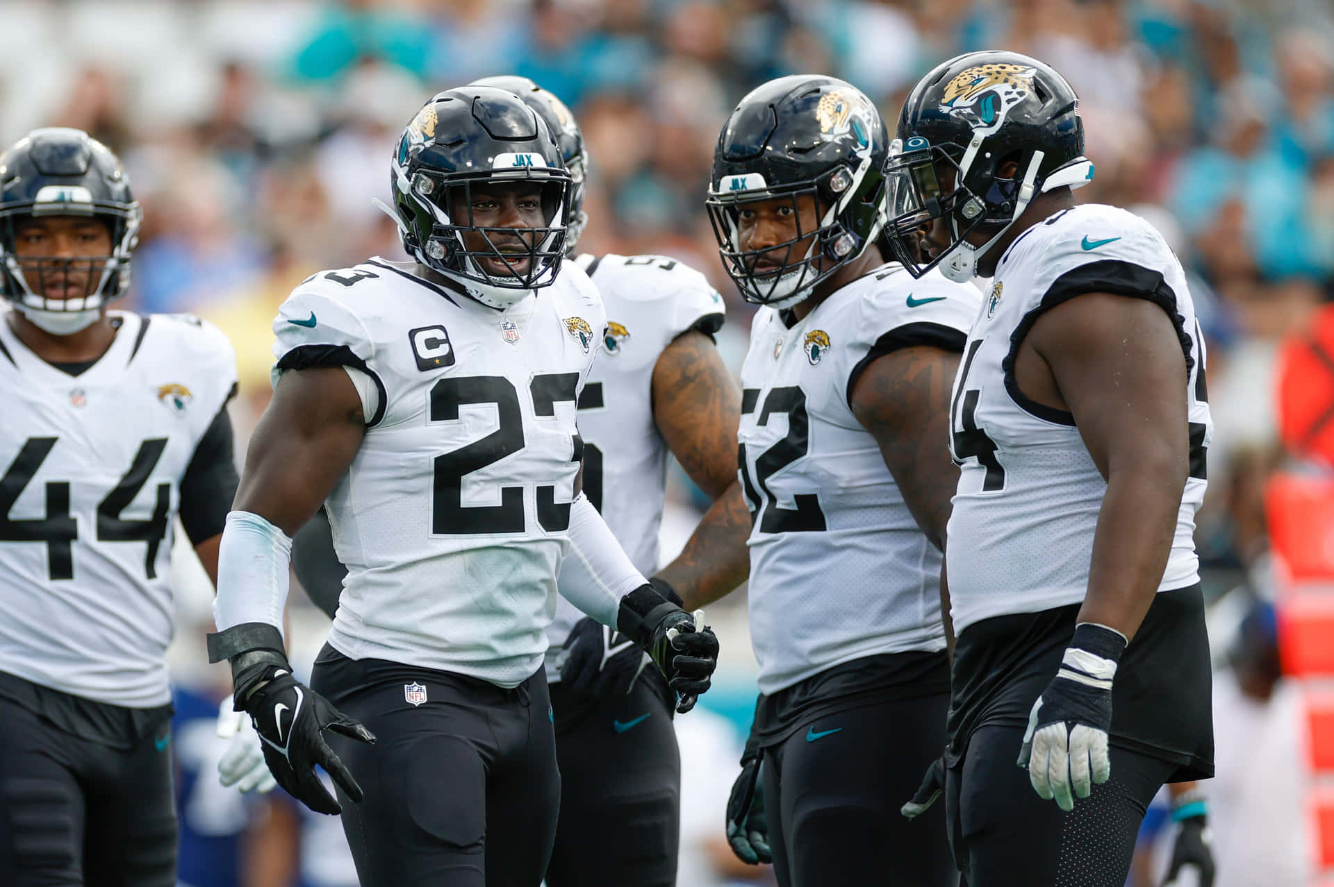 Jaguars Team Captainand Players Walkingon Field Background