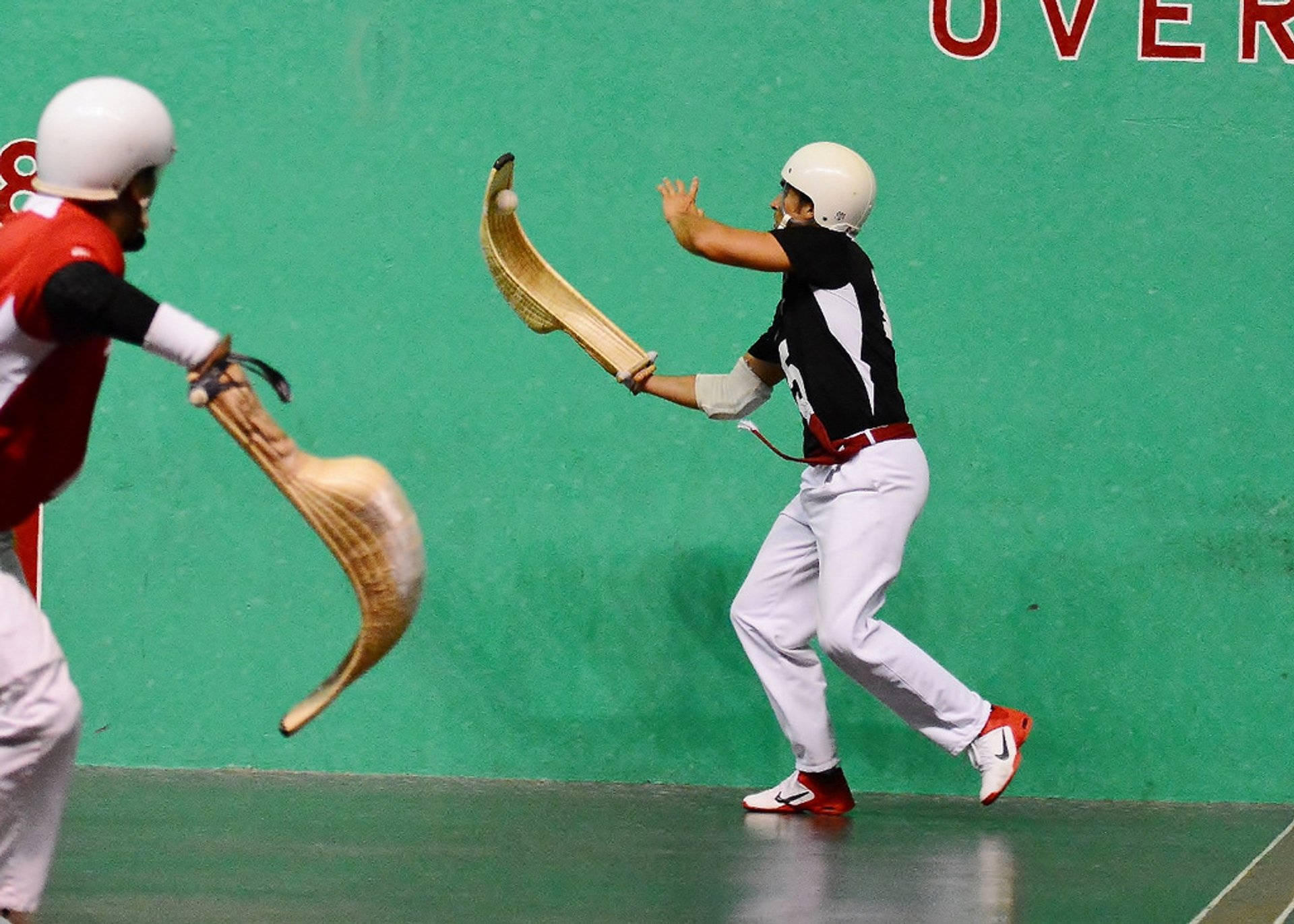 Jai Alai Players In Dynamic Game Action Background