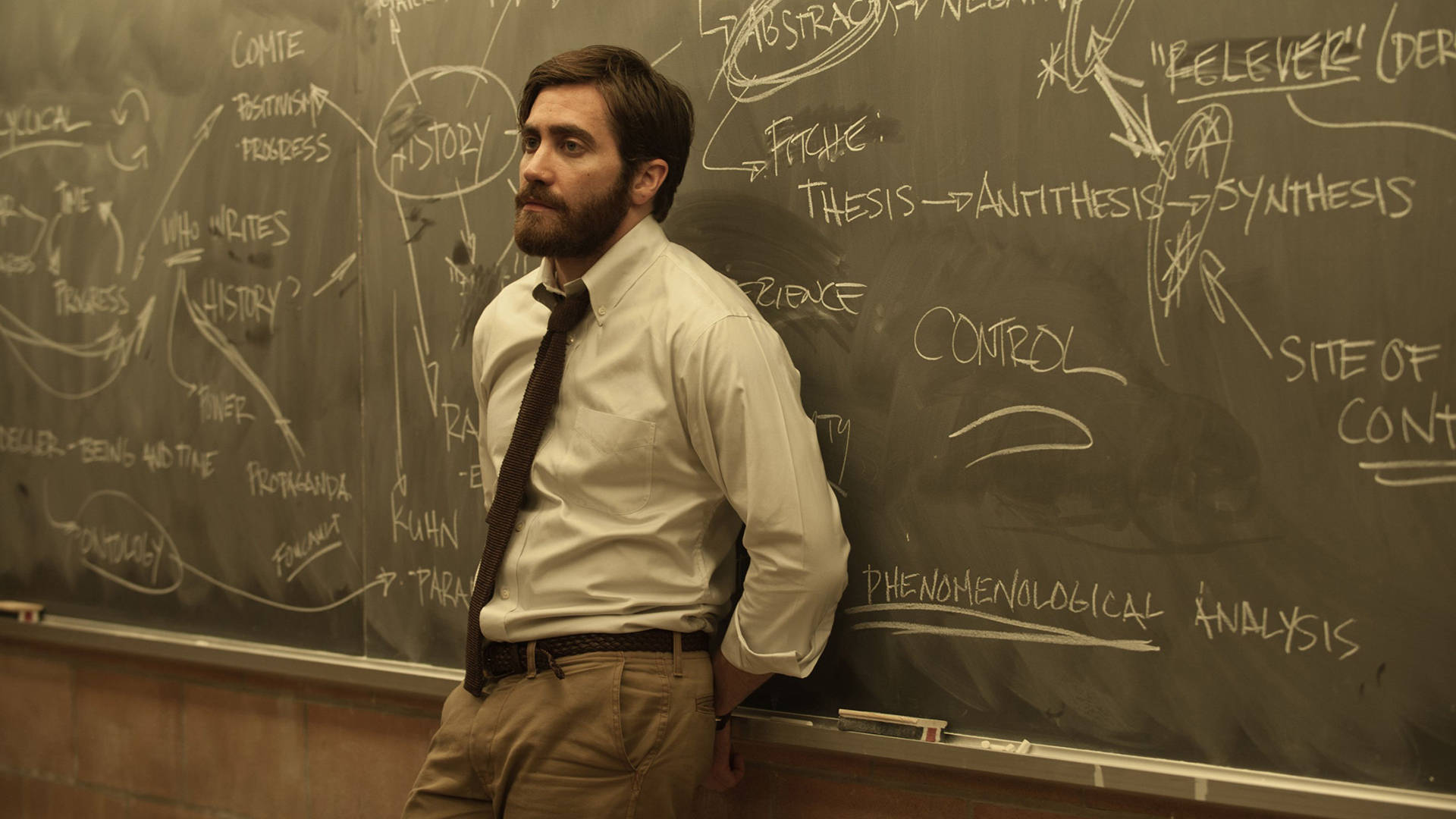 Jake Gyllenhaal Leaning On Blackboard Background