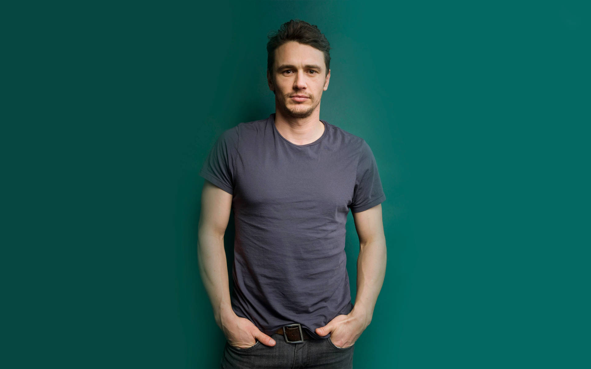 James Franco In Grey Shirt Against A Vibrant Green Background Background