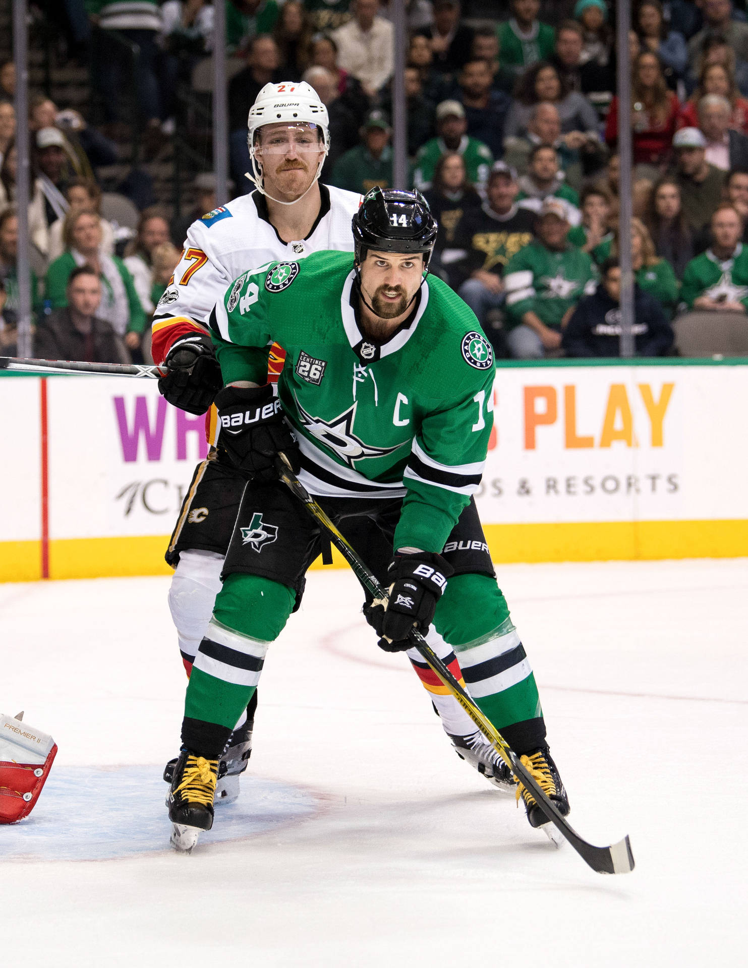 Jamie Benn Being Held Against An Opposing Player Background