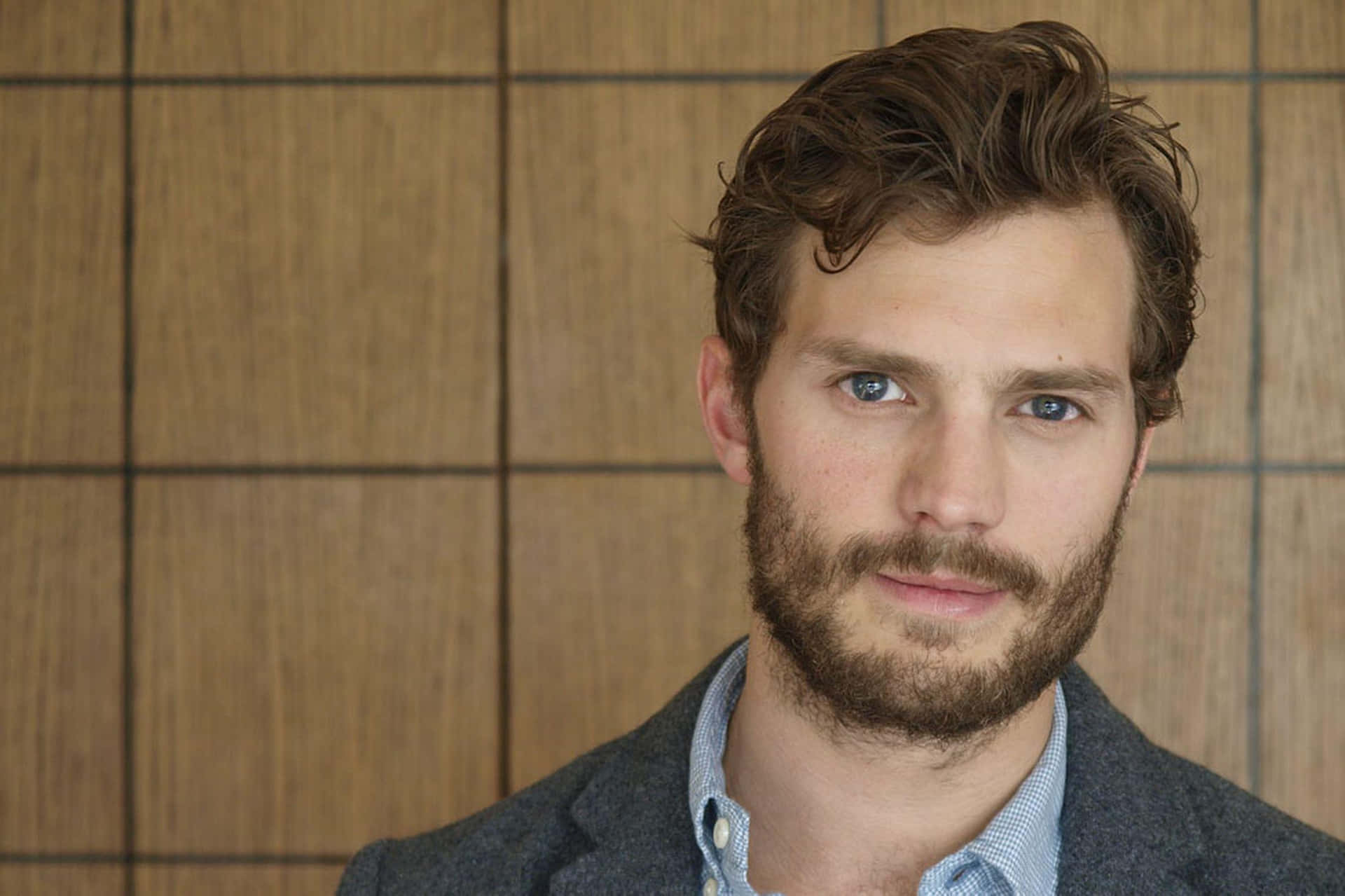 Jamie Dornan Striking A Pose In A Stylish Suit Background