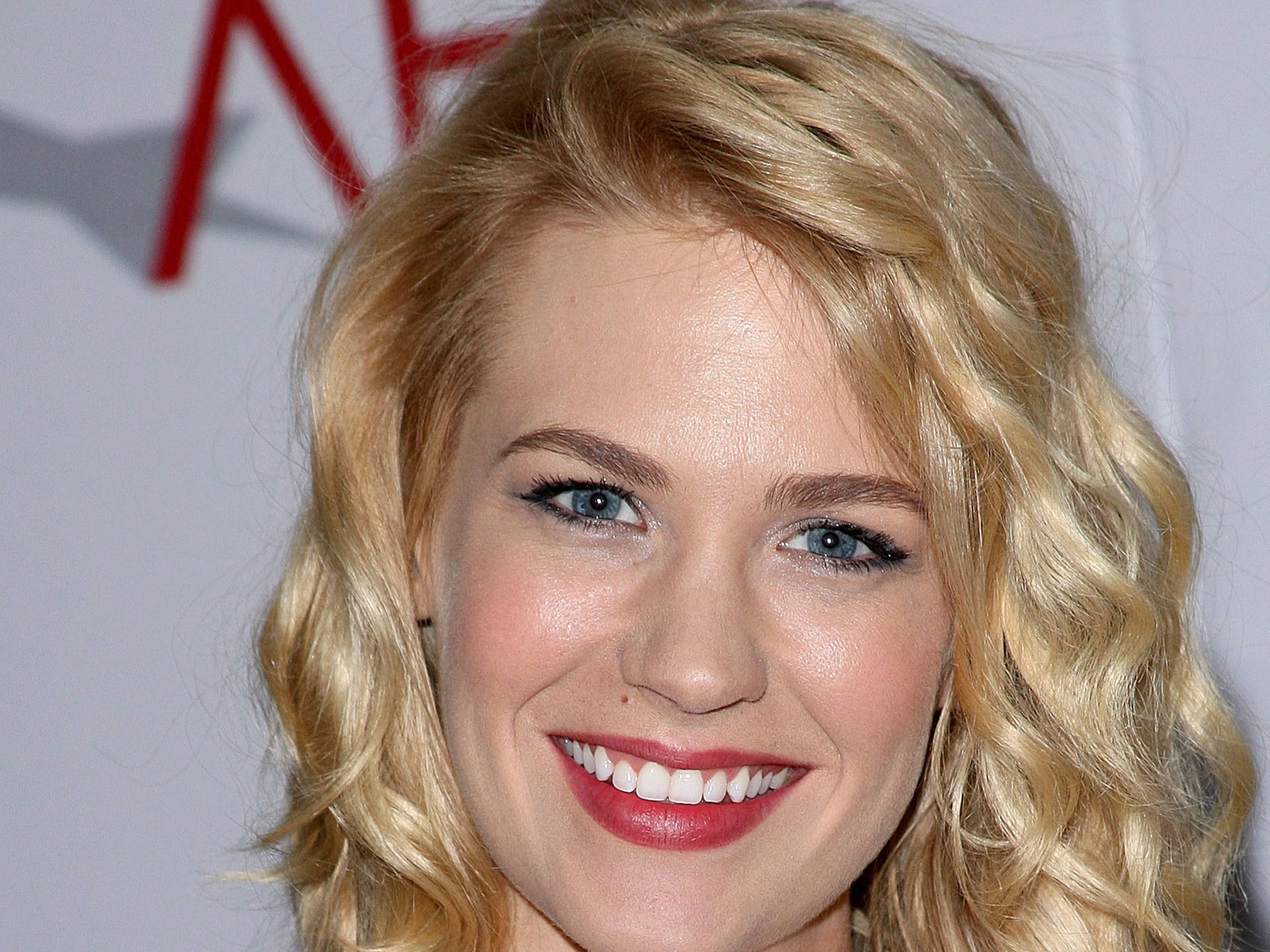 January Jones Sporting Elegant Wavy Curls Background