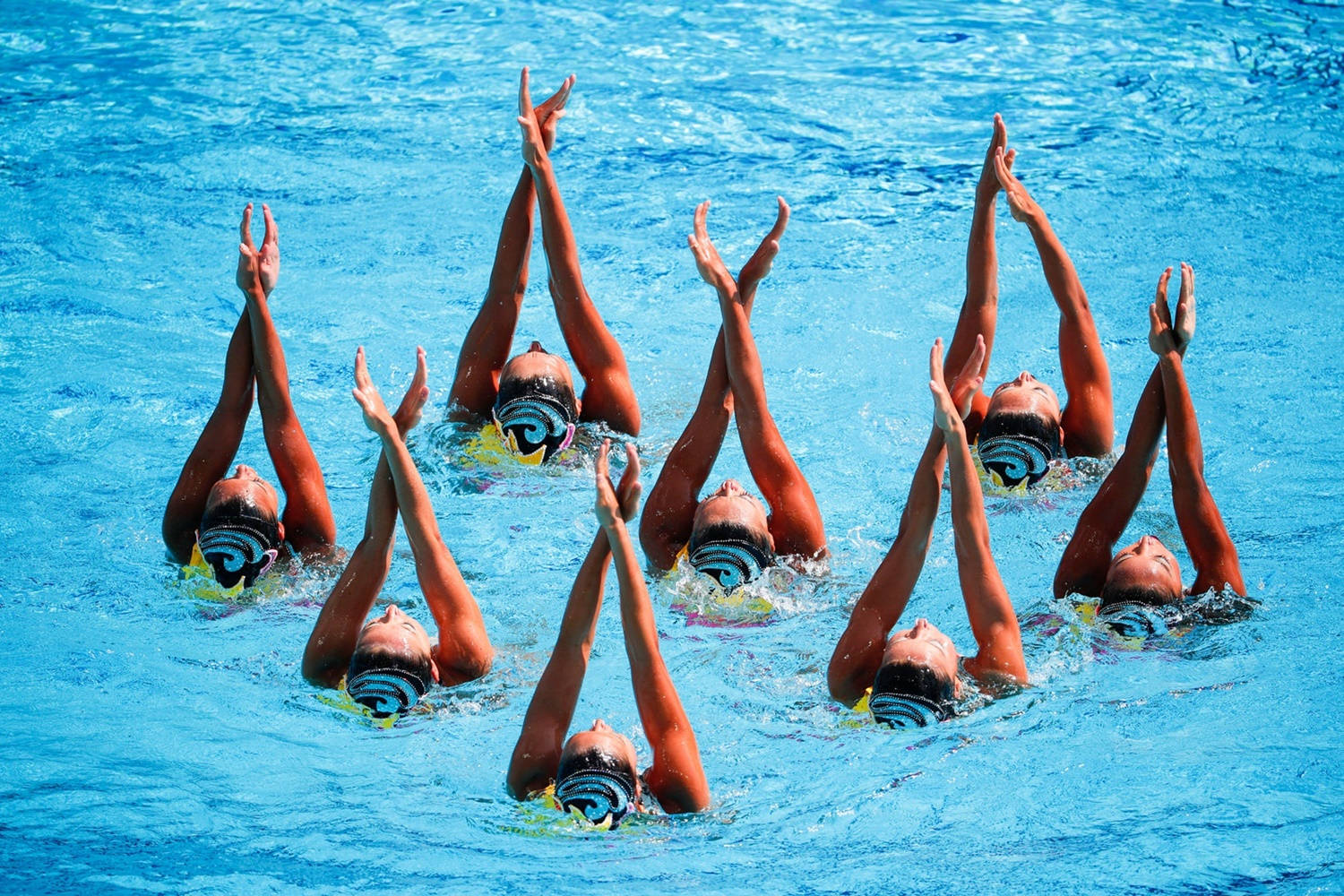 Japanese Synchronized Swimming Team Performing Intricate Routine Background