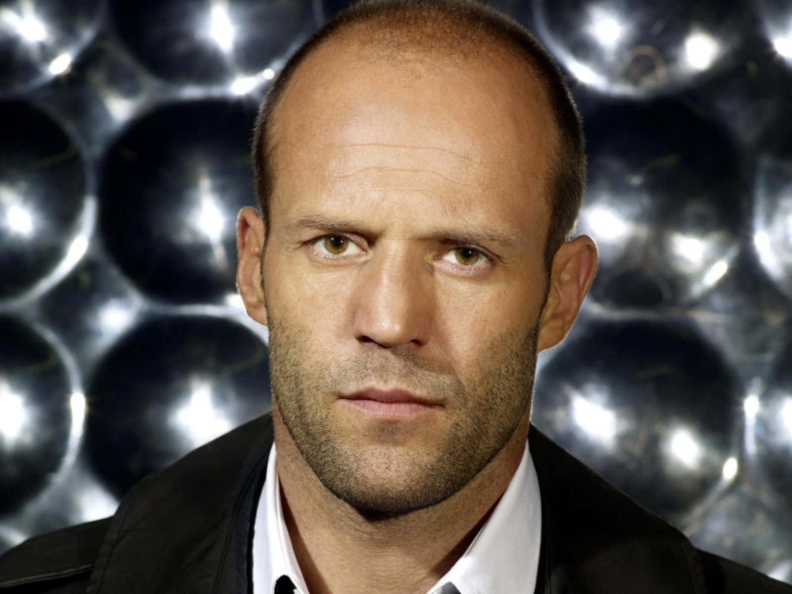 Jason Statham Exhibiting Confidence With His Iconic Bald Look Background