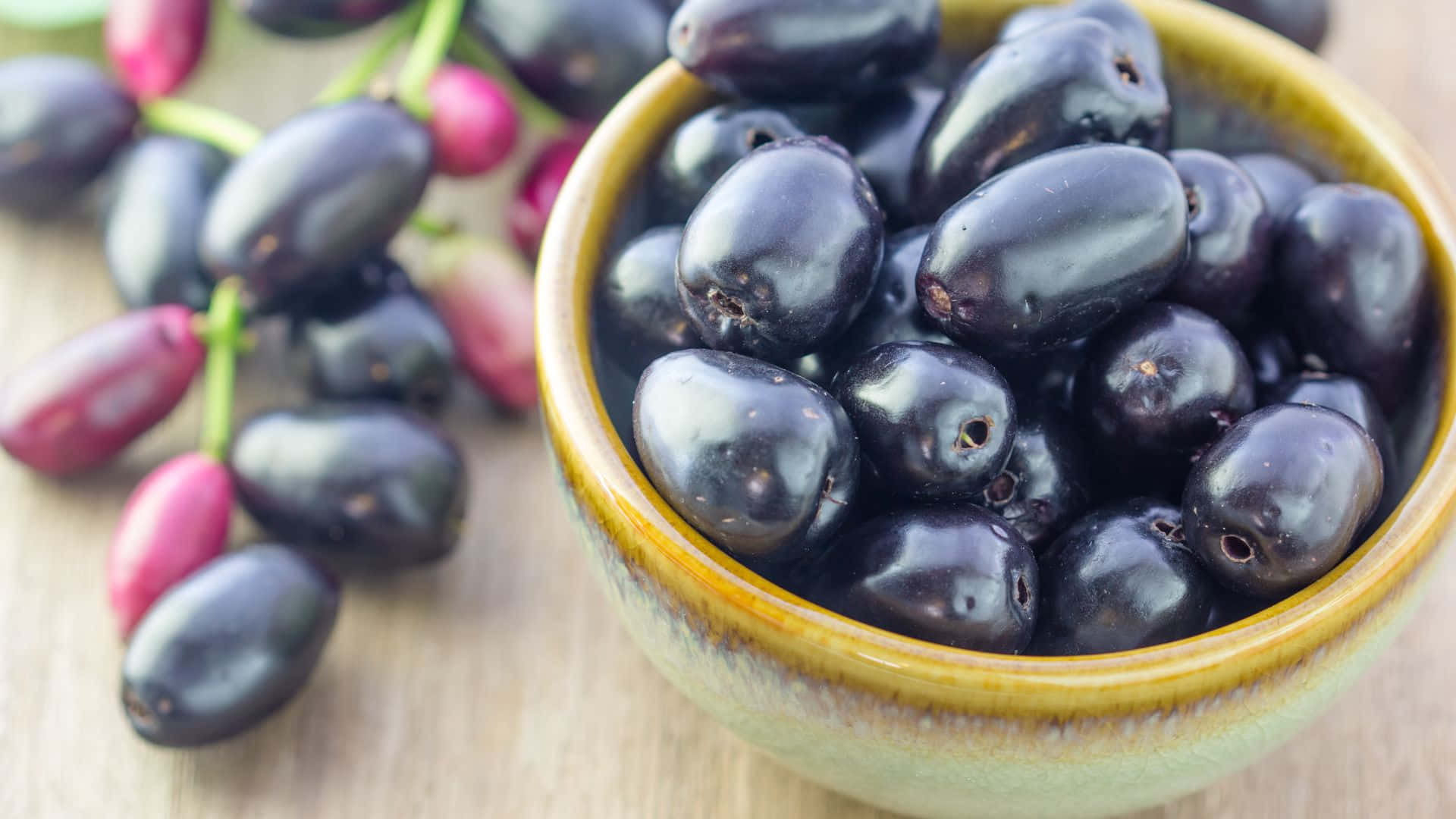 Java Plums In A Ceramic Bowl Background