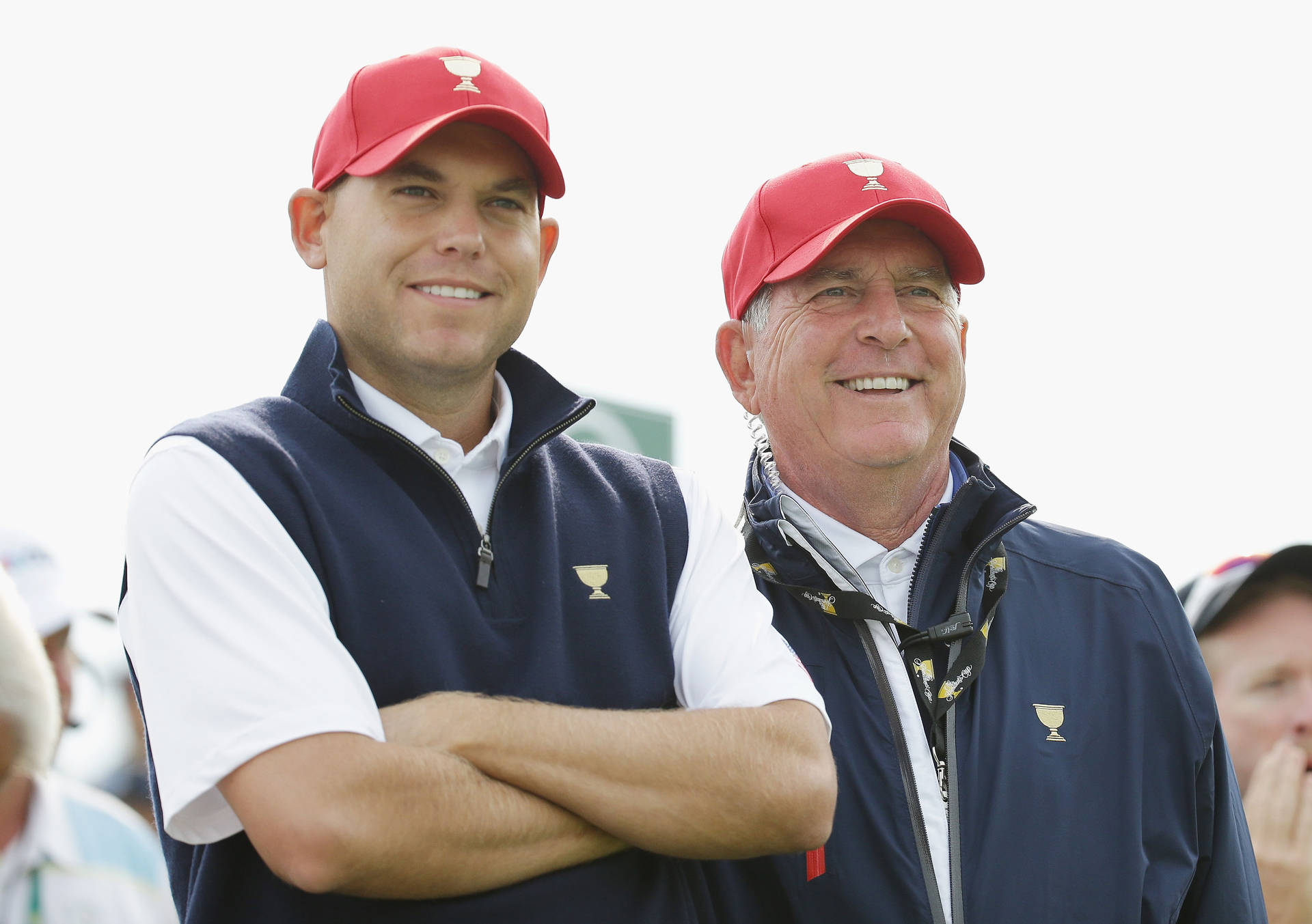 Jay Haas And Son Watching Golf Match Background