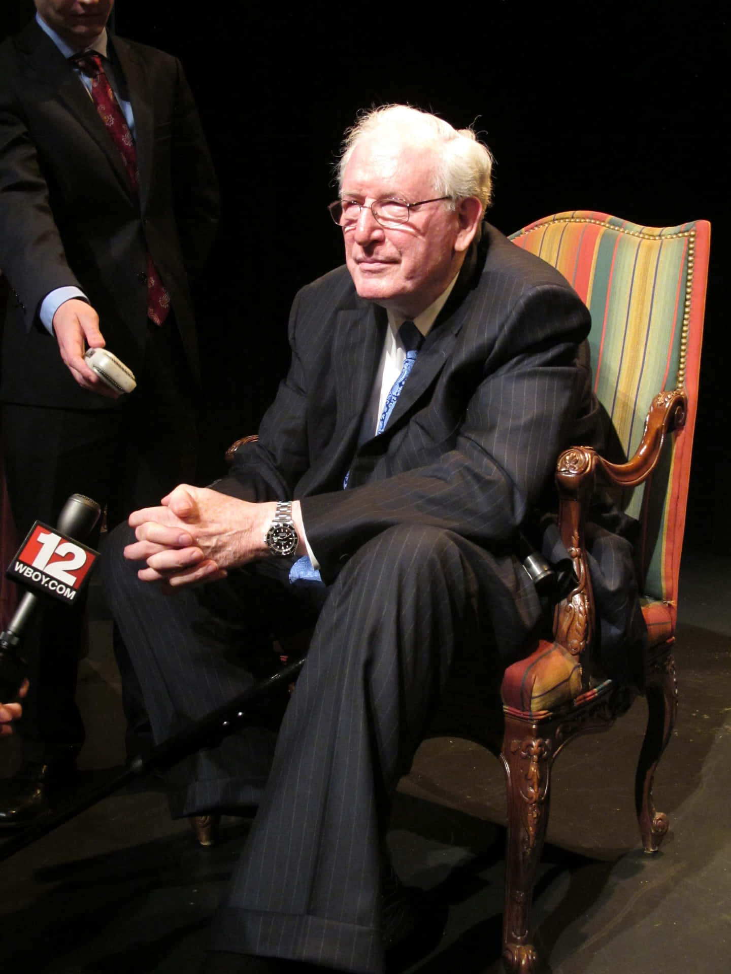 Jay Rockefeller Sitting On Colorful Chair Background