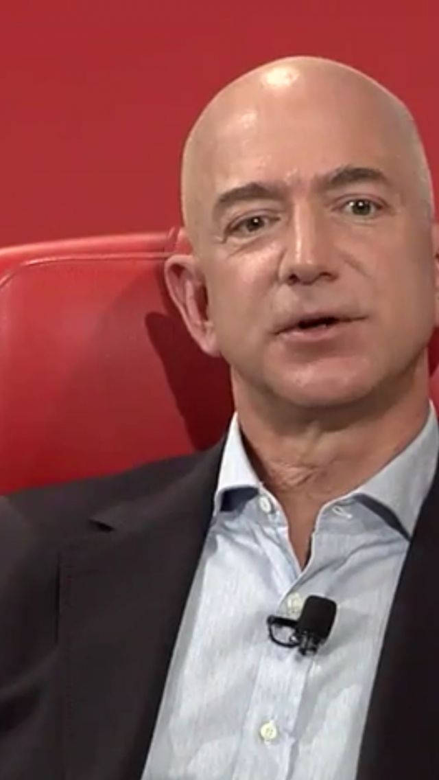 Jeff Bezos Against A Red Backdrop Background