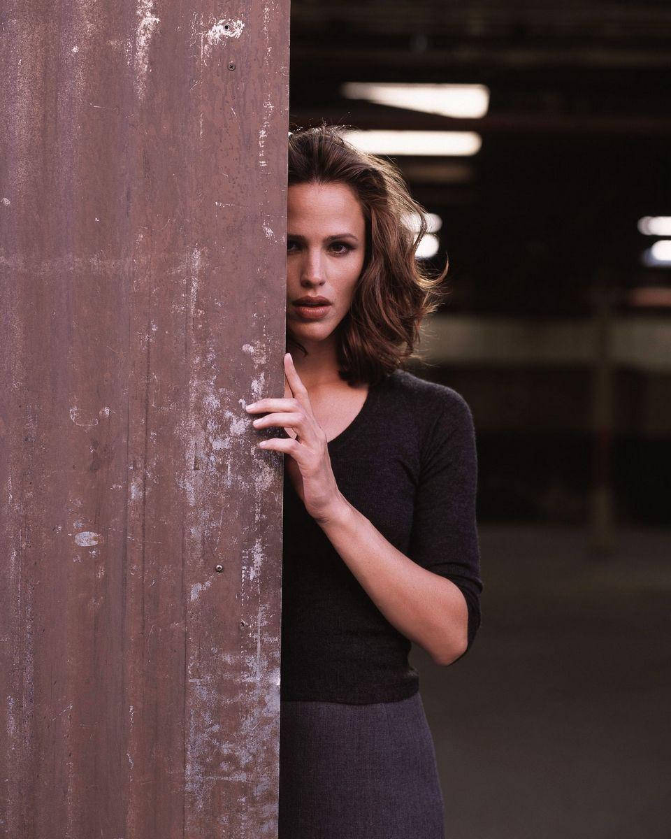 Jennifer Garner Peeking From A Wall Background