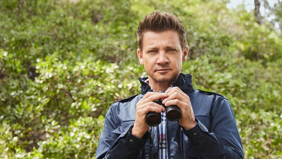 Jeremy Renner Analyzing Landscape With Binoculars Background