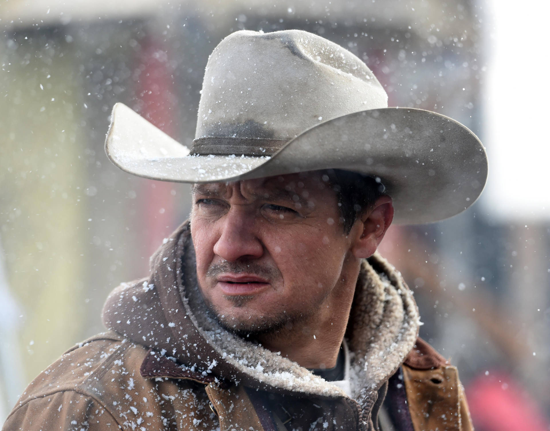 Jeremy Renner With A Cowboy Hat Background