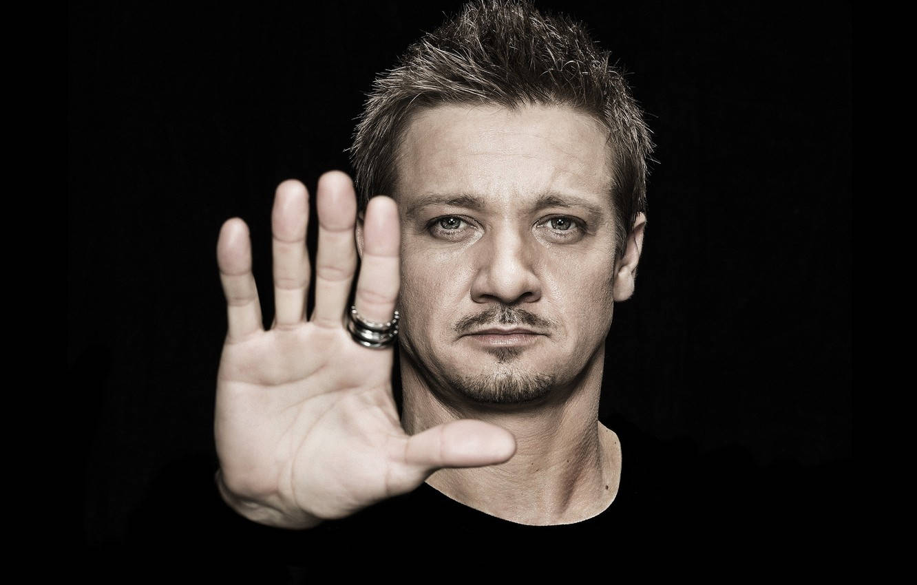 Jeremy Renner With An Open Palm Background