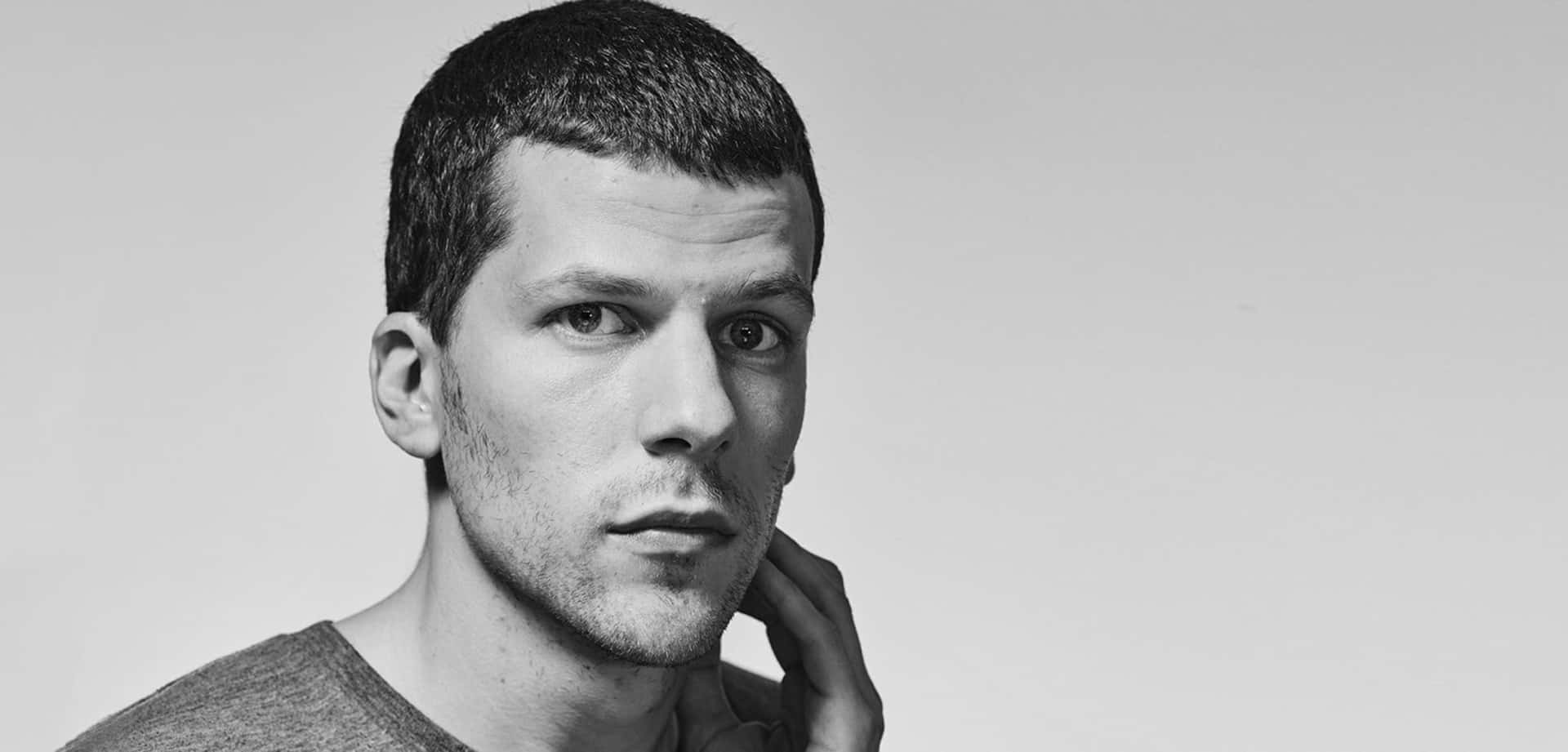 Jesse Eisenberg Smiling In A Casual Photoshoot Background