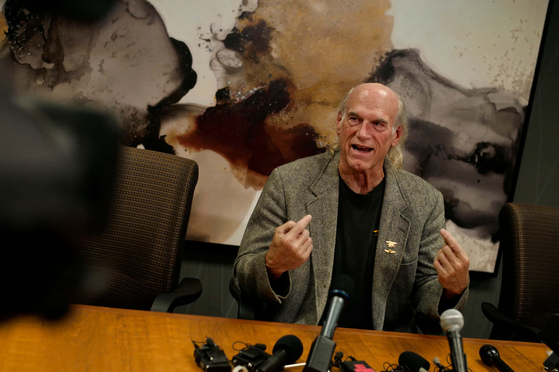 Jesse Ventura Speaking At A Media Event Background