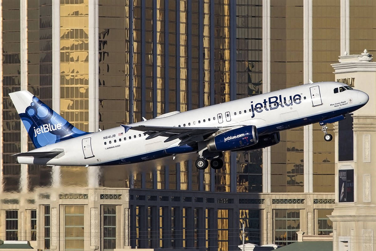 Jetblue Airplane By City Buildings Background