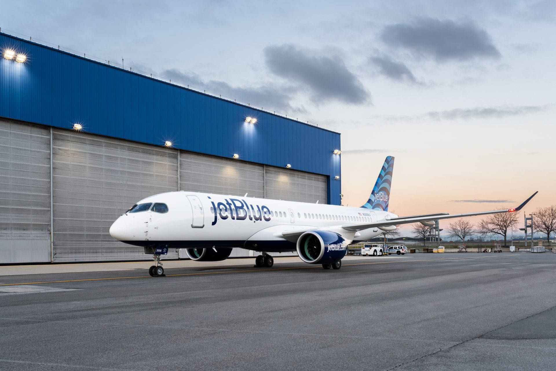 Jetblue Airways Plane By The Airport Hangar Background