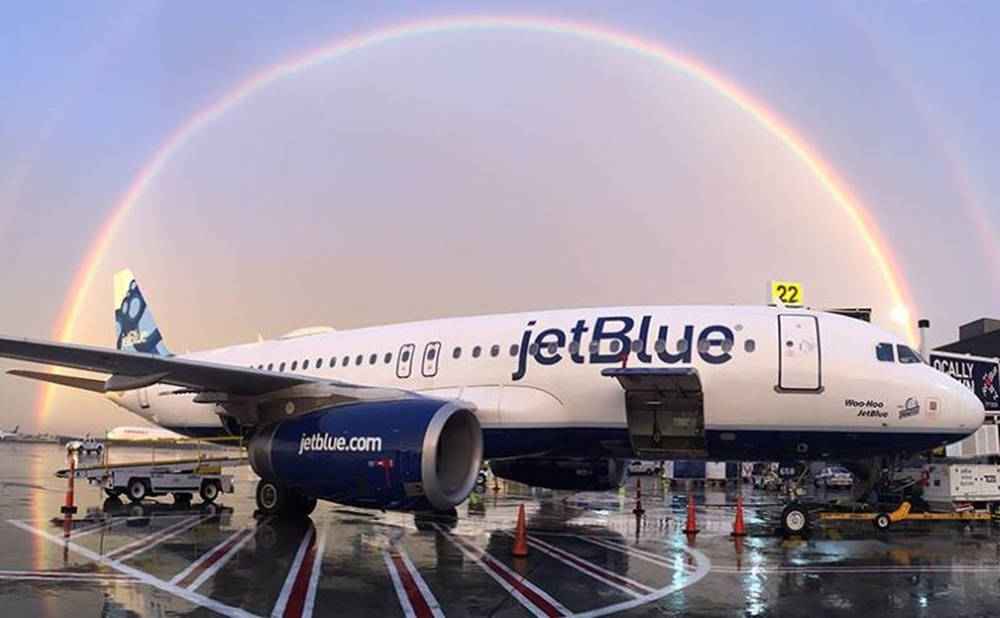 Jetblue Airways Plane Under A Rainbow Background