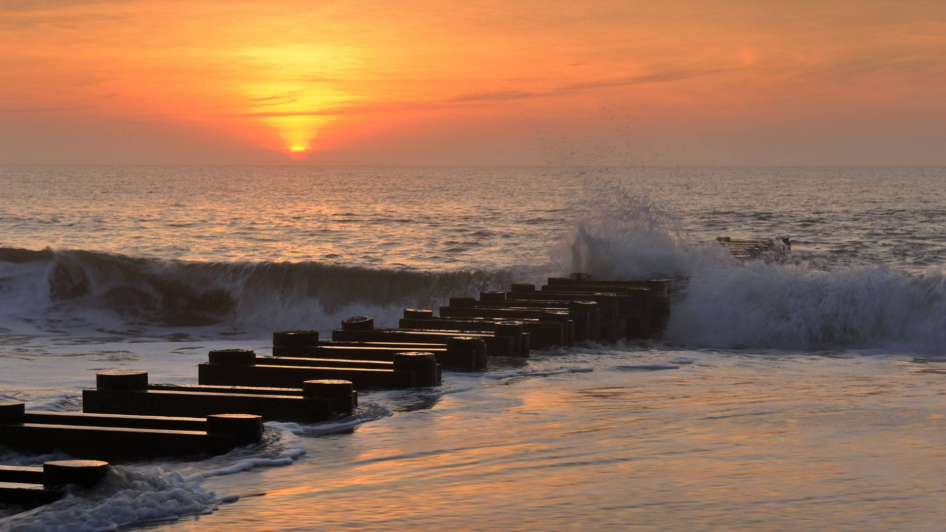 Jetty Pile With Wave On Beach Sunrise Background