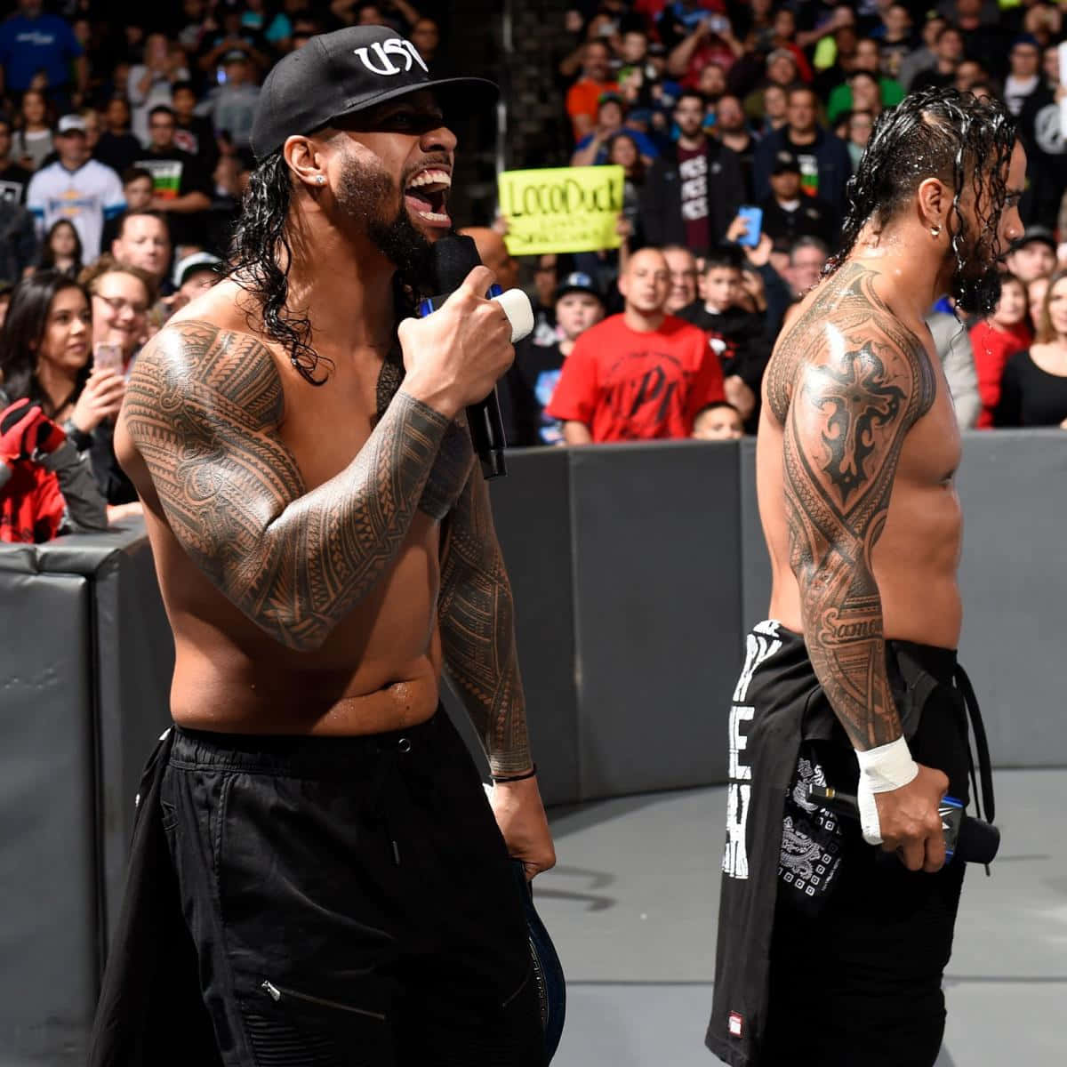 Jey Uso Alongside His Twin Brother Jimmy Uso Showcasing Their Brotherly Bond In The Ring. Background