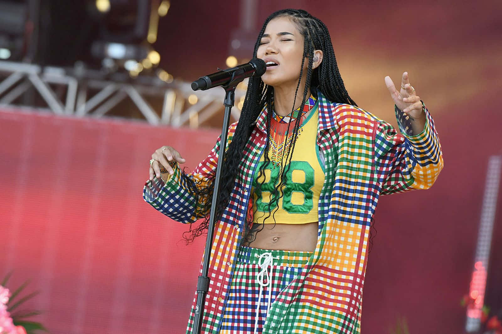 Jhené Aiko Striking A Pose In A Blue Outfit Background