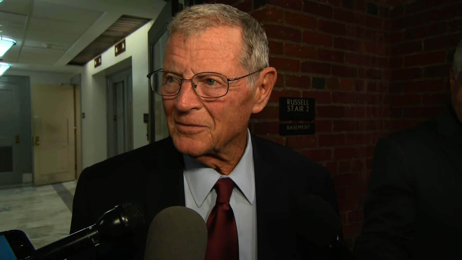 Jim Inhofe With Two Microphones Background
