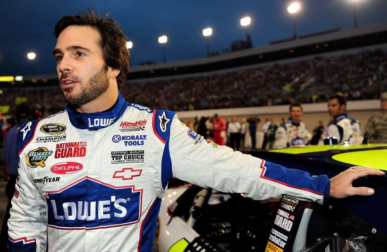 Jimmie Johnson Posing With His Nascar Stock Car Background