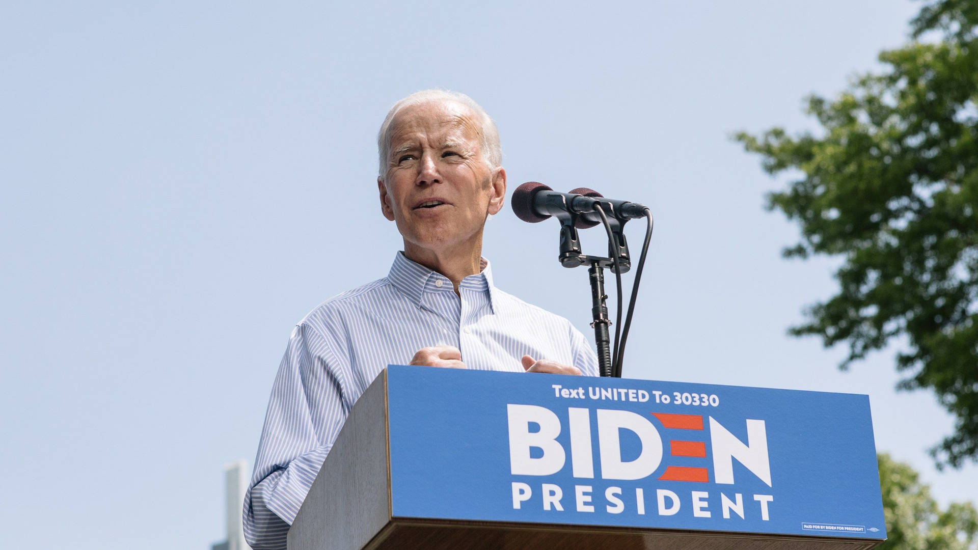 Joe Biden Delivers Powerful Speech On Stage Background