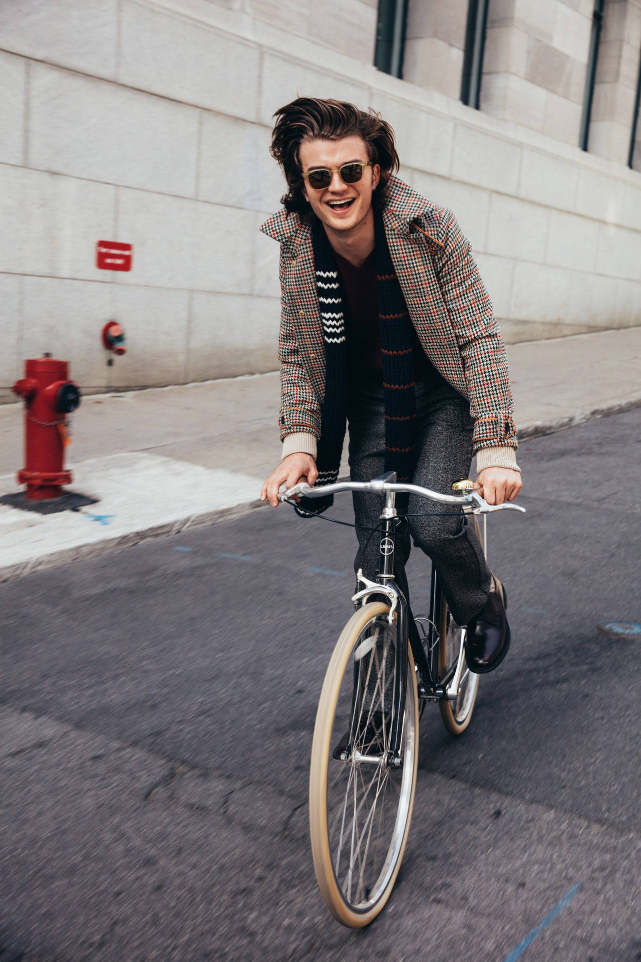 Joe Keery Riding A Bike Background