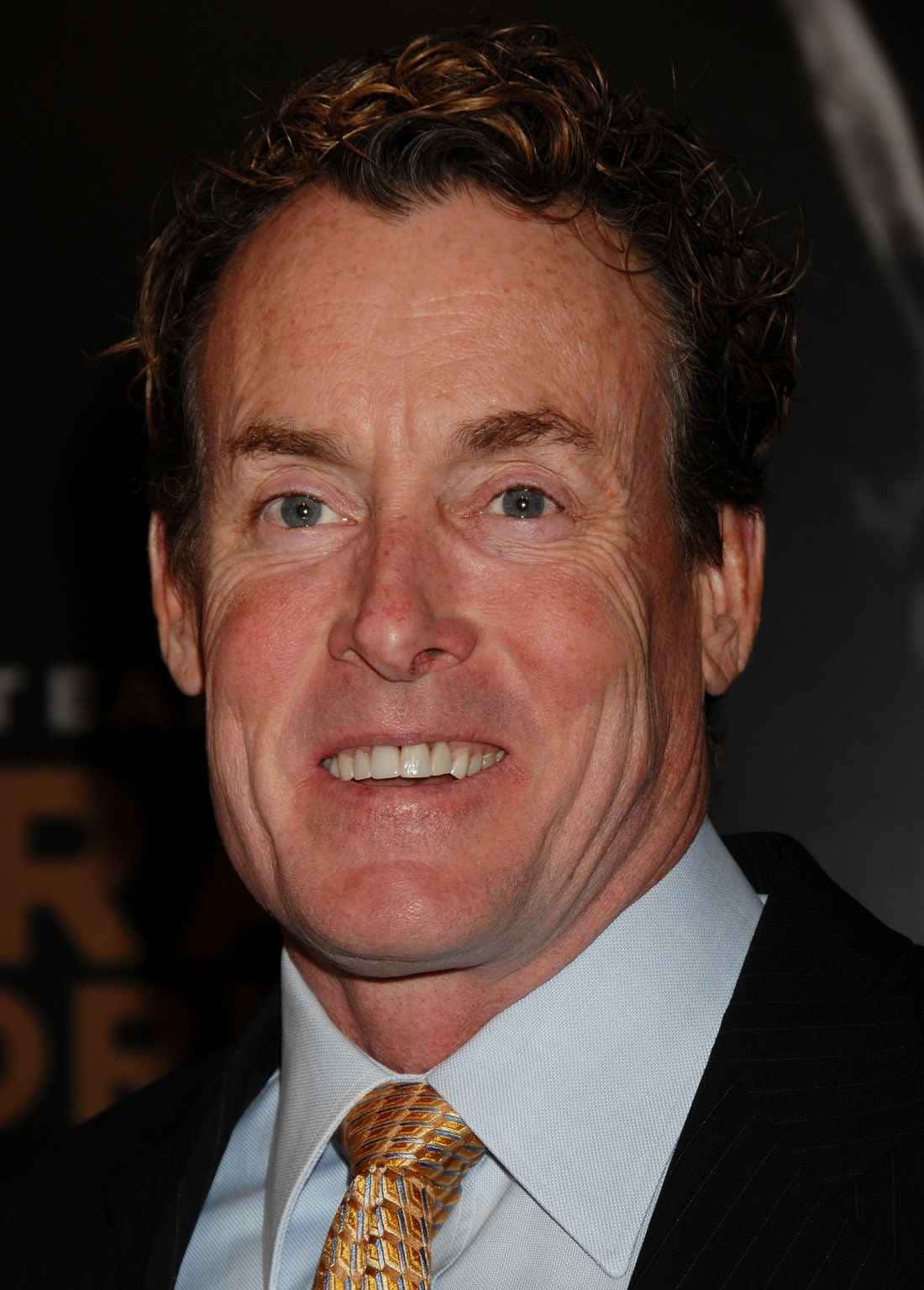 John C. Mcginley Smiling In A Photoshoot Background