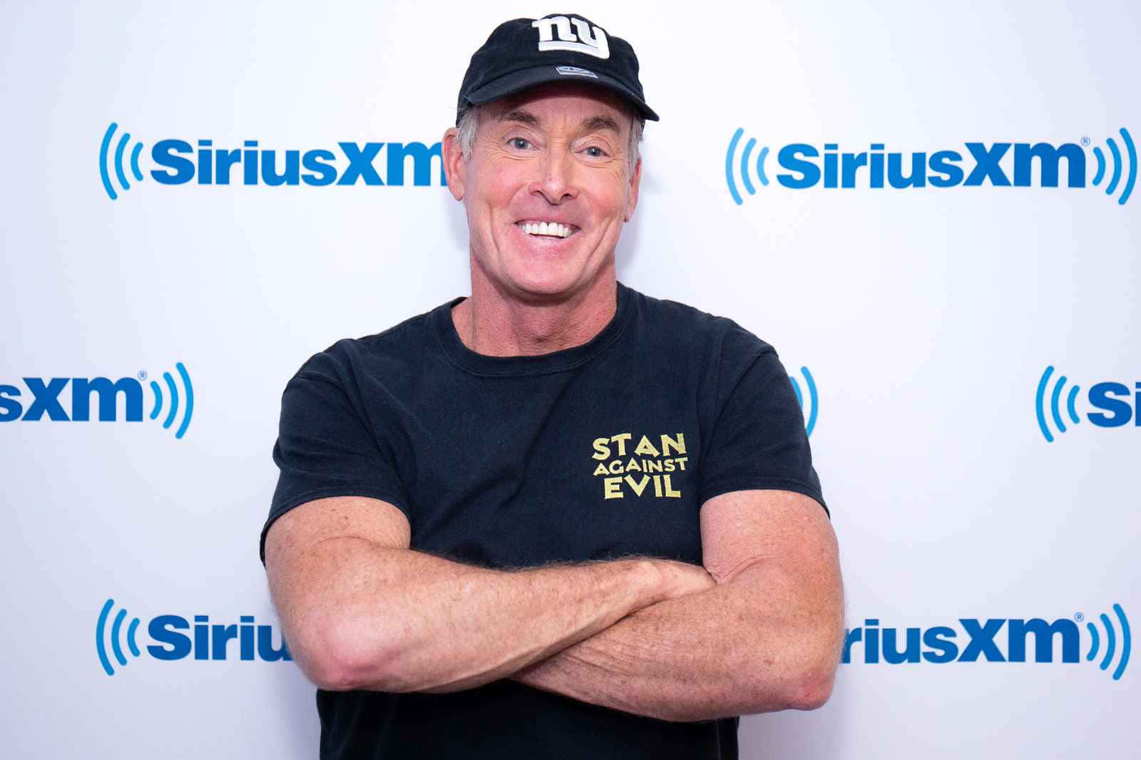 John C. Mcginley Smiling In A Relaxed Pose Background