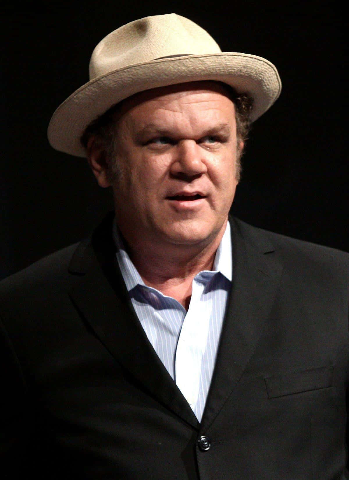 John C. Reilly Striking A Casual Pose On A Gray Background