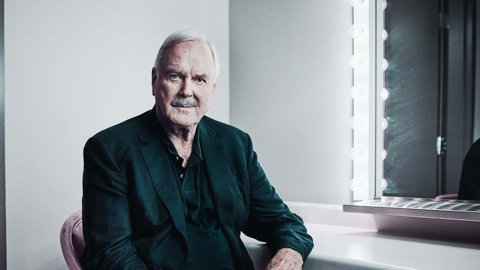 John Cleese Engaging In A Candid Moment Background