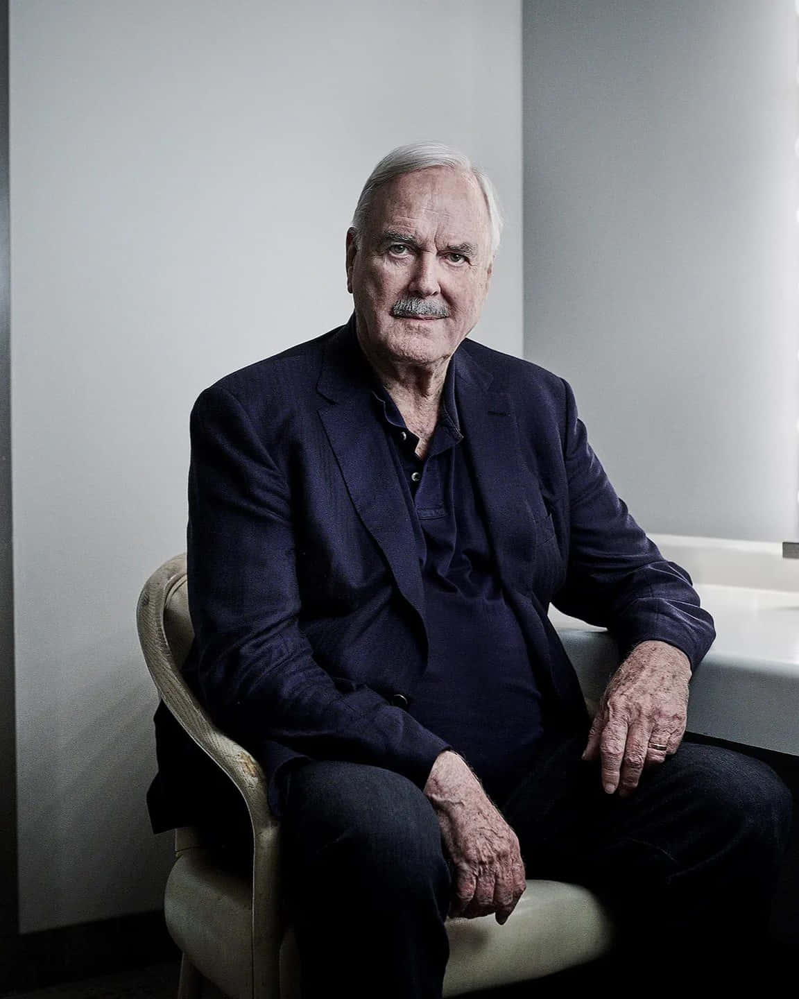 John Cleese Portrait Sitting Background