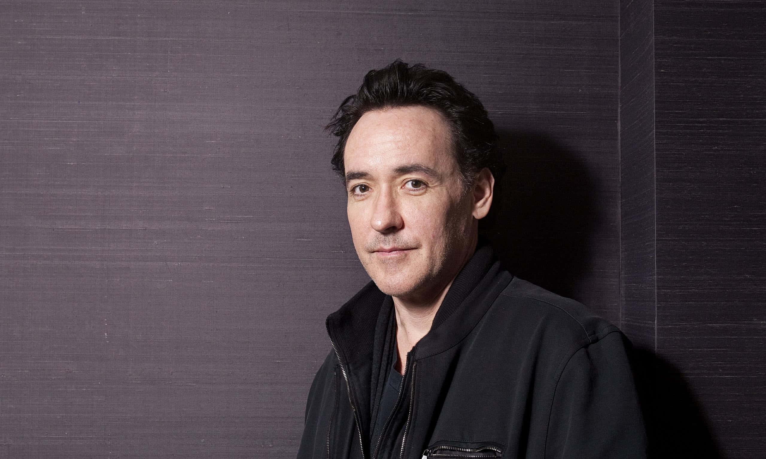 John Cusack Smiling At The Camera In A Casual Attire Background