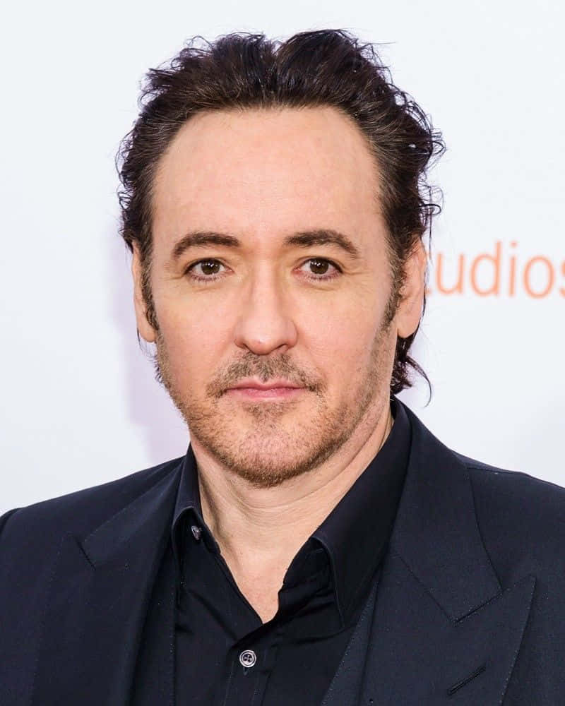John Cusack Smiling In A Portrait Background