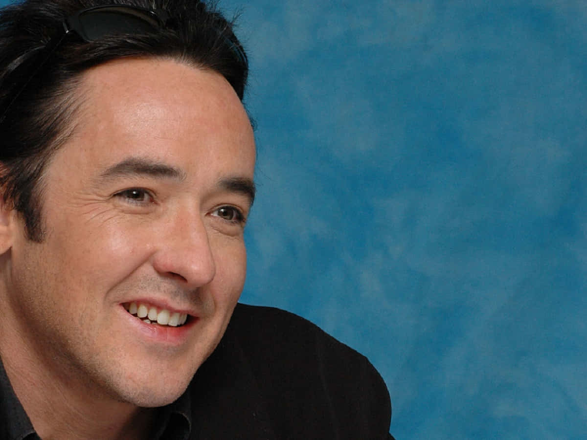John Cusack Standing In A Stylish Pose Background