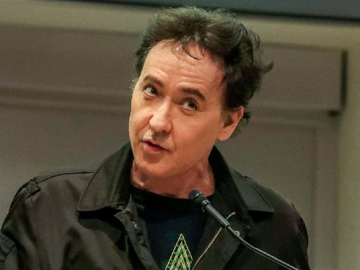 John Cusack, The Iconic Actor, Poses In A Thought-provoking Stance. Background