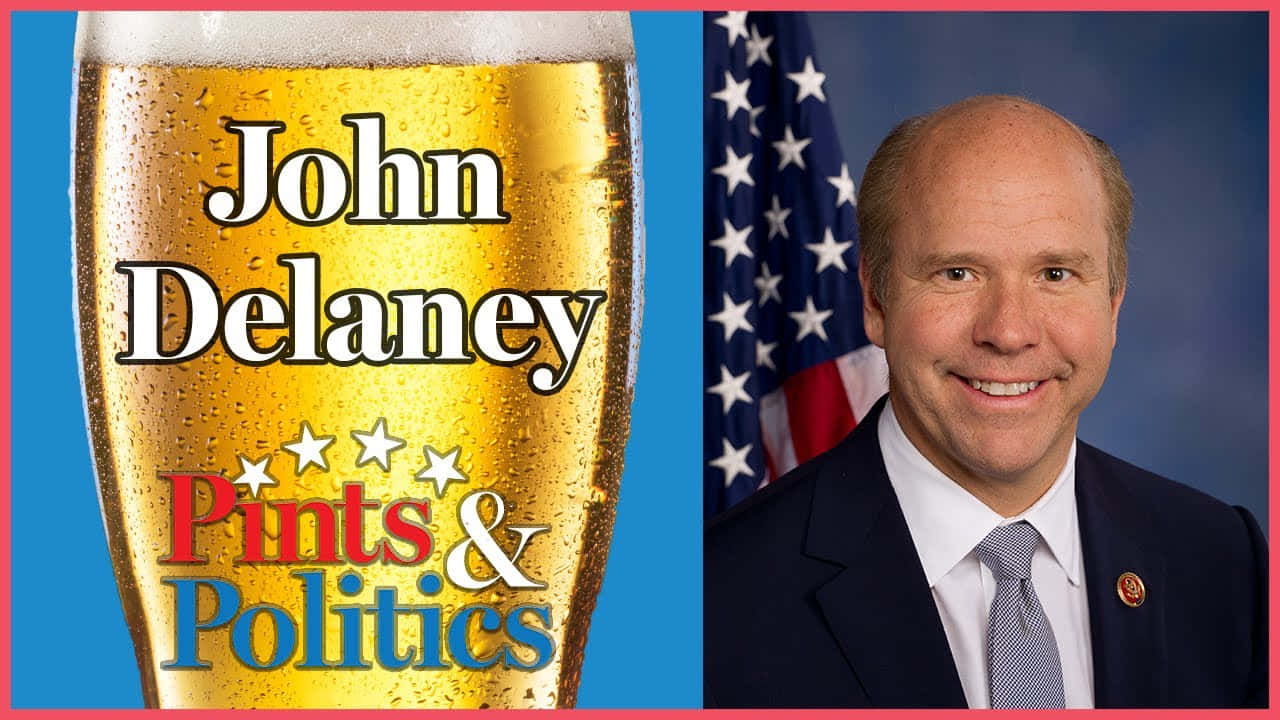 John Delaney Giving A Powerful Speech On Stage Background