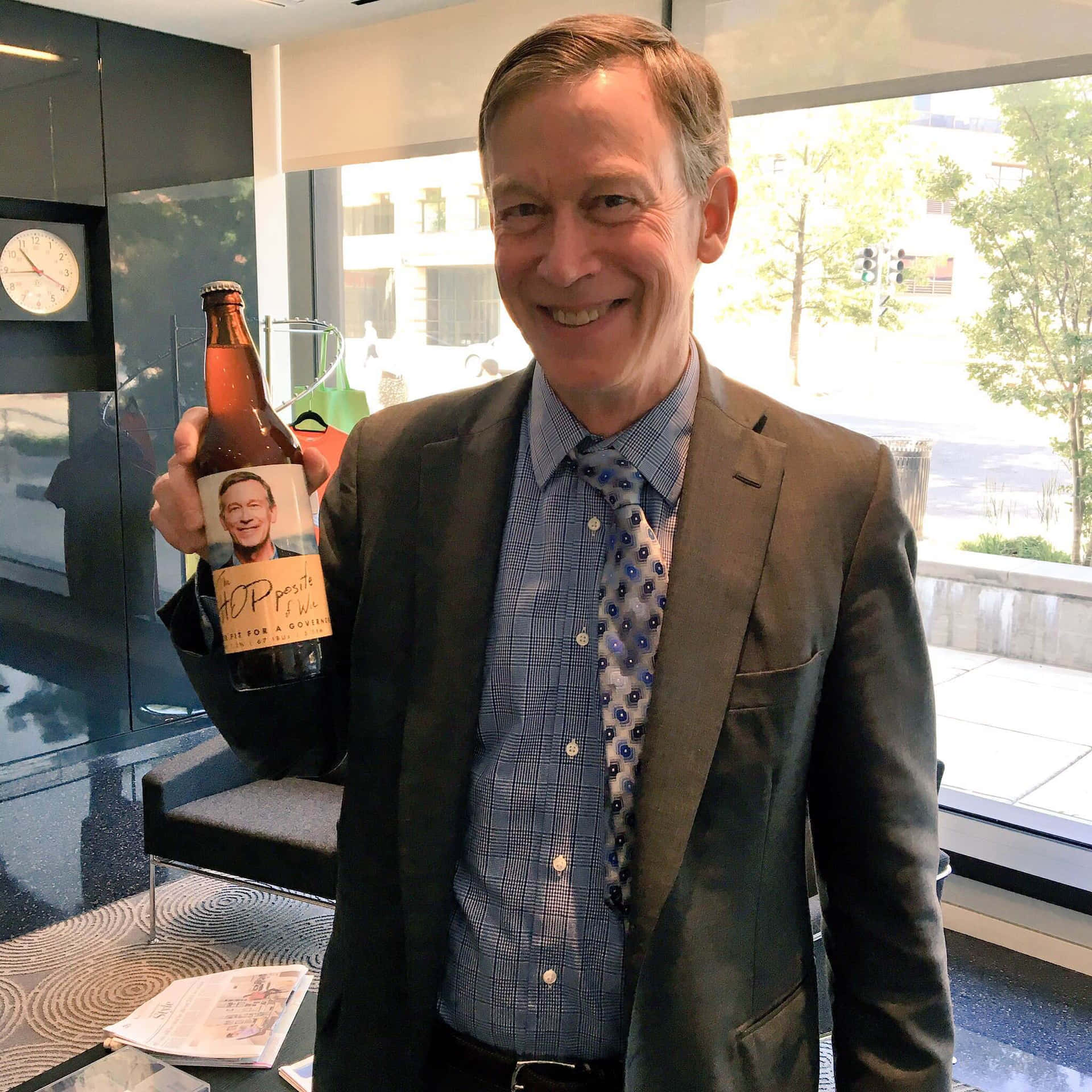John Hickenlooper Holding A Bottle Of Beer Background
