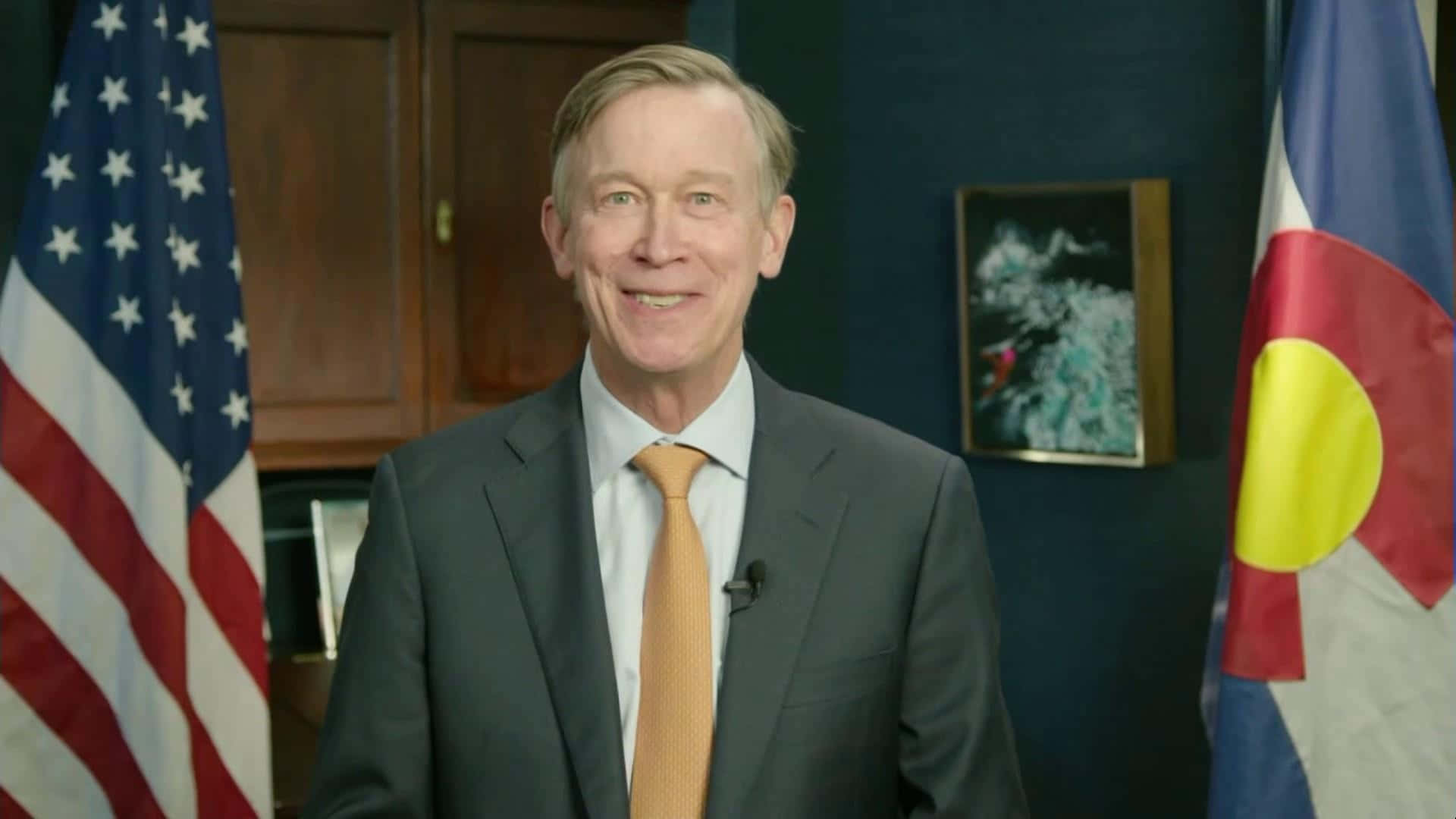John Hickenlooper Standing In Front Of American Flag